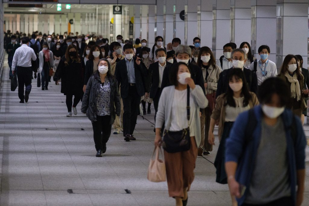 東京、大阪、京都、兵庫の各地域で新型コロナウイルスによる緊急事態宣言が発令される中、2021年5月7日、東京の新宿駅構内をマスクを着用して歩く人々。(AFP)