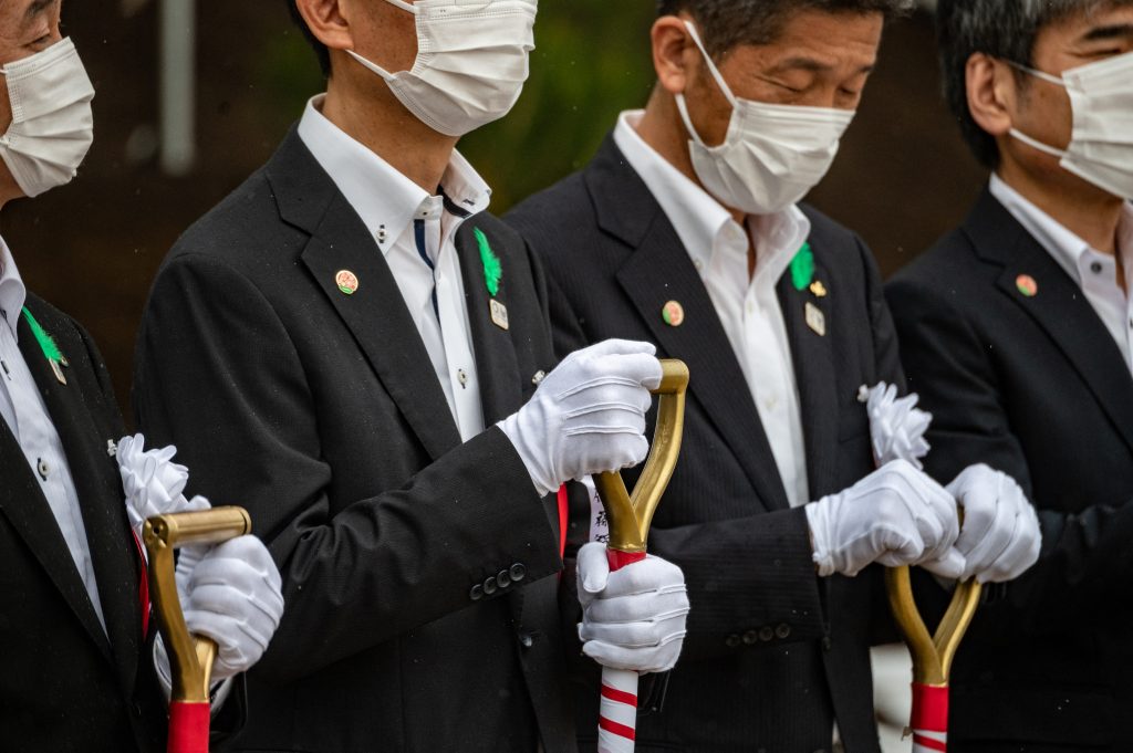 東京五輪・パラリンピックの競技会場「有明アリーナ」での復興祈念植樹を終え写真撮影に応じる、右から、岩手、宮城、(1人おいて)福島、熊本各県の東京事務所長=6日午後、東京都江東区 (AFP)