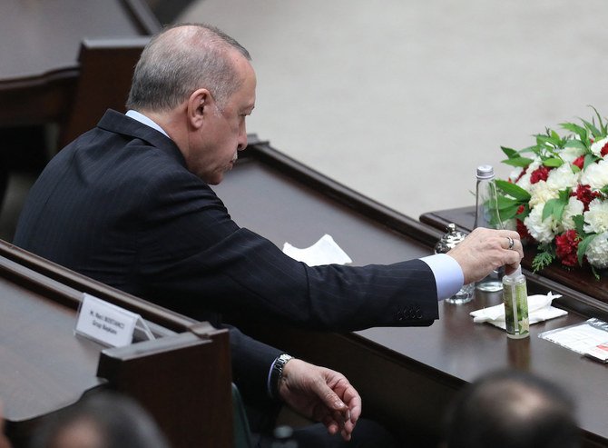 2021年5月26日、アンカラで開催されたトルコ大国民議会 (GNAT) で行われた与党公正発展党のグループ会合で、手を消毒するトルコのレジェップ・タイイップ・エルドアン大統領 。(AFP)