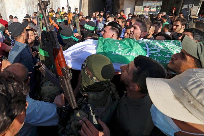 イスラエル軍がガザ地区に投下した爆弾の解体と報道されている作業で亡くなった2名の兵士のうち1名の遺体を搬送するカッサム旅団のパレスチナ人メンバー。イスラエル軍はハマス指導者をヨルダン川西岸地区で逮捕したと話している。（AFP）