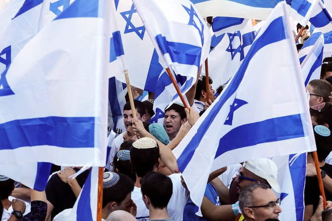 2021年6月15日、エルサレム旧市街の外で旗を持ちながら歩くイスラエル人。（ロイター通信）