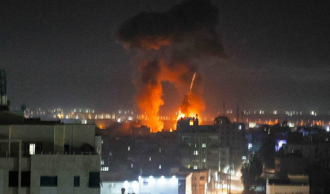 ガザ市のビル上の夜空に光る爆発。パレスチナの飛び領土に向けたイスラエル軍の砲撃である。2021 年 6 月 16 日早朝。(AFP)