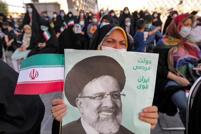 イランの首都テヘランのイマーム・フセイン広場で、イランの新大統領エブラヒム・ライシ師のポスターを持つ女性。 (AFP)