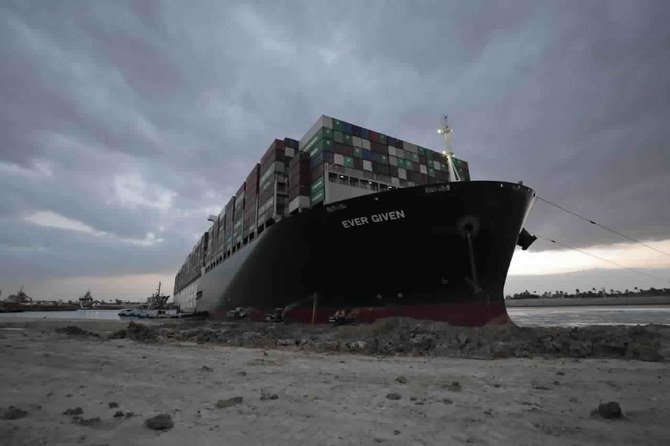 今年、スエズ運河で1週間近く座礁した日本企業が所有するパナマ船籍の「エバーギブン」の離礁作業にあたるタグボートと掘削機。 (AP)