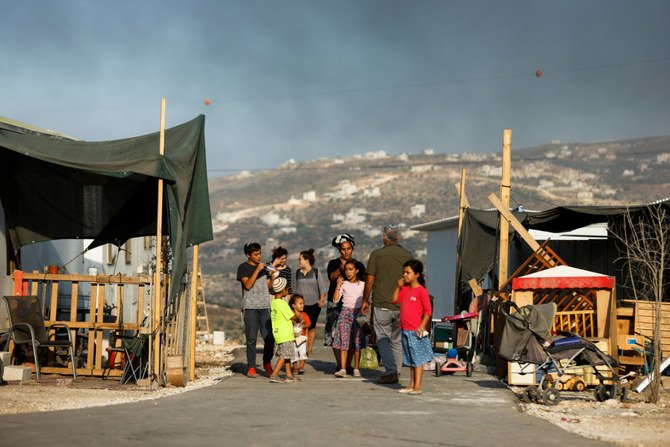 2021年6月23日、ヨルダン川西岸のパレスチナ人が住むベイタ村の近くにある、新しいイスラエルの辺境の入植地、ギバト・エビアタルで、ユダヤ人入植者が並んで立っている。（ロイター通信/アミール・コーエン）