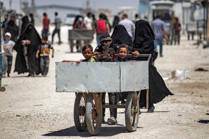 2021年6月23日、シリアのハサカにある、クルド人が運営するアルホル・キャンプで、青年がカートを、子供を乗せながら押している。このキャンプは、ダーイッシュのテロ容疑者の親族を収容している。(AFP /デリル・スレイマン)