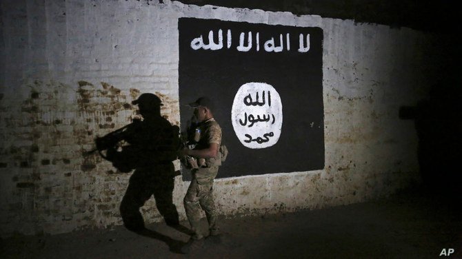 2017年3月1日に撮影されたこの写真は、「イスラム国」の旗が飾られたトンネルを調査するイラク兵の姿を捉えている。（AP通信ファイル写真）　