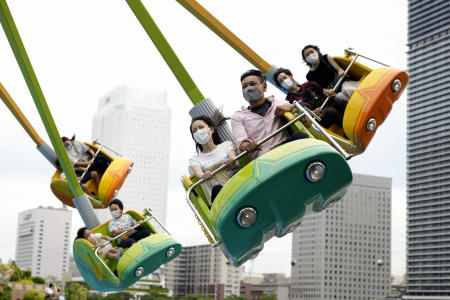 フェイスマスクを着用した方は、2021年6月20日(日)に東京近郊の横浜にある遊園地でアトラクションに乗って楽しみます。(AP)
