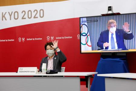 2021年6月21日に東京の晴海トリトンスクエアY棟で開催された5者協議で挨拶を交わす、東京五輪・パラリンピック組織委員会の橋本聖子会長(左)と、国際オリンピック委員会(IOC)のトーマスバッハ会長(画面上)。(AFP)