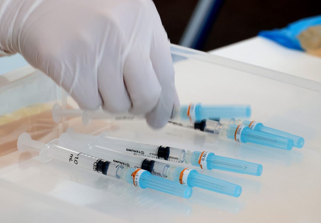 2021年6月18日、東京都庁で2020年東京五輪関係者を対象としたワクチン接種が開始され、新型コロナウイルスワクチンを投与するために注射器を選ぶ医療従事者。 (AFP)