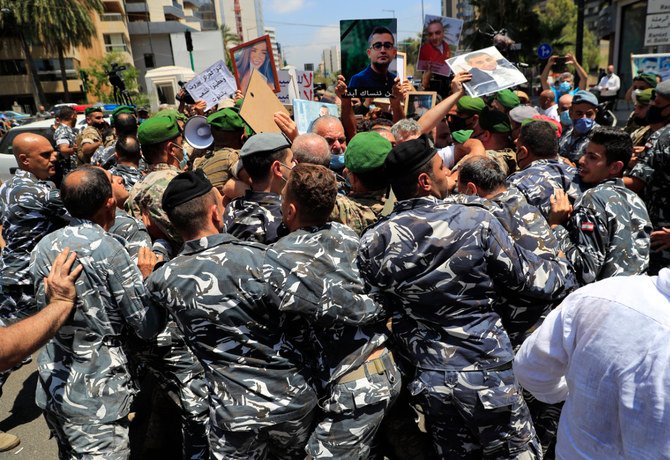 昨年発生したベイルート湾爆発事故の遺族たちが、2021年7月9日にベイルート市内で抗議する中、レバノン国民議会ナビハ・ベリ議長の警備員らが彼らを押し戻している。（AP）