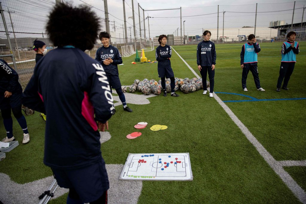 2021年3月31日、埼玉県飯能市。日本女子サッカーチームのちふれASエルフェン埼玉の選手たちが練習中コーチの声に耳を傾けている。世界中で女子サッカーへの関心が熱狂的に高まる中、元世界王者の日本は日本初となる女子プロサッカーリーグの誕生とともに栄光への復活を狙う。（AFP）
