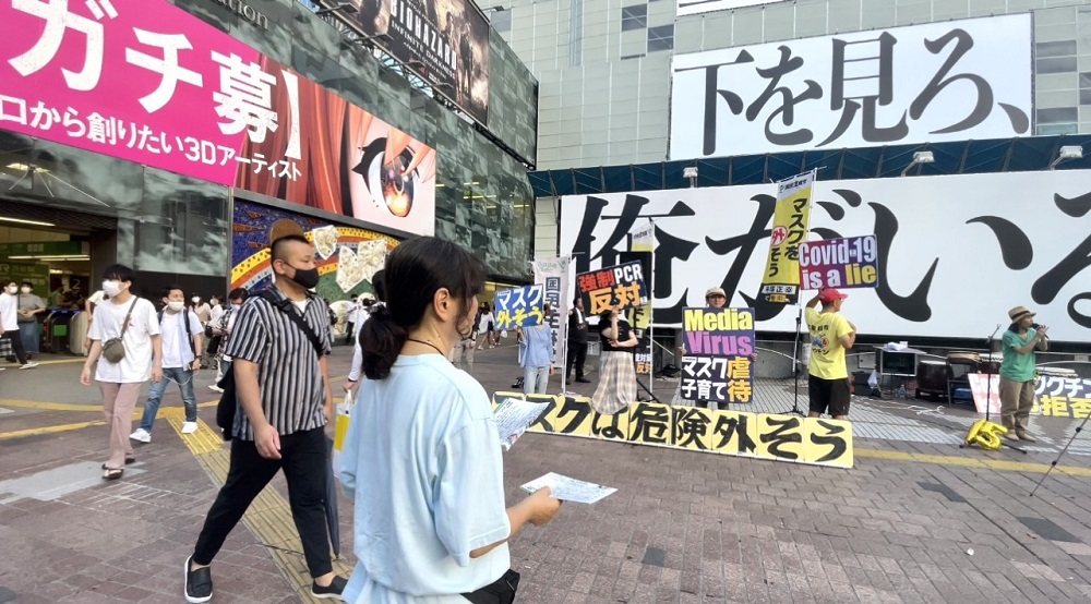 Covid-19に反対する抗議者は、東京の混雑した渋谷スクランブル広場に集まり、PCRテストに反対するプラカードを掲げ、マスクは「嘘」だと。(ANJの写真)