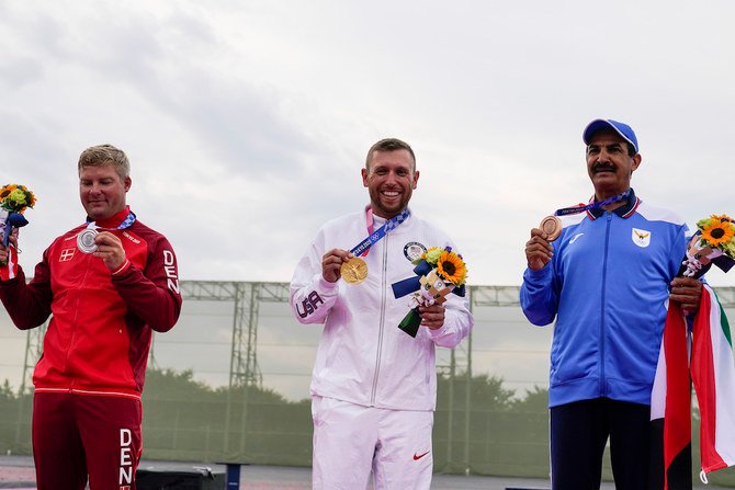 東京2020オリンピックの男子射撃スキート競技の後、表彰台で喜ぶ銀メダリスト、デンマークのイェスパー・ハンセン選手、金メダリスト、アメリカのビンセント・ハンコック選手、銅メダリスト、クウェートのアブドゥッラー・アルラシーディ選手（左から）。（AP）