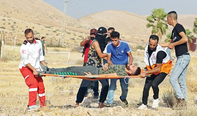 占領地ヨルダン川西岸地区北部でのイスラエル人入植者との衝突で負傷したパレスチナ人抗議活動家を避難させる医療従事者たち。（資料写真/AFP通信）