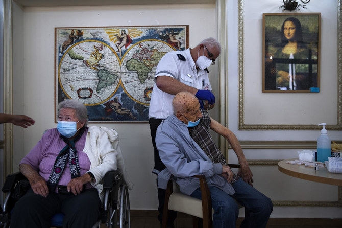 この2021年1月13日に撮られた資料写真の中で、男性が、イスラエルのラマトガンにある民間の老人ホームで、ファイザー社/バイオンテック社の新型コロナワクチンの2回目の接種を、イスラエルの救助活動組織「マゲン・ダビド・アドム」のボランティアから受けている。（AP）