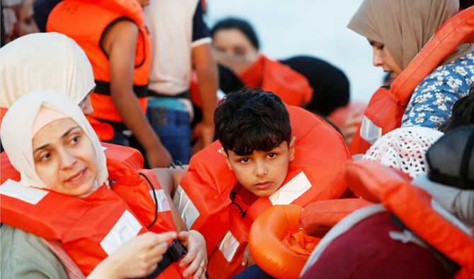 2021年7月30日、地中海西部のリビア沖の国際水域で、ドイツのNGO移民救助船『シーウォッチ3』の乗組員に救助されるのを船の中で待つ移民たち。（ロイター通信）