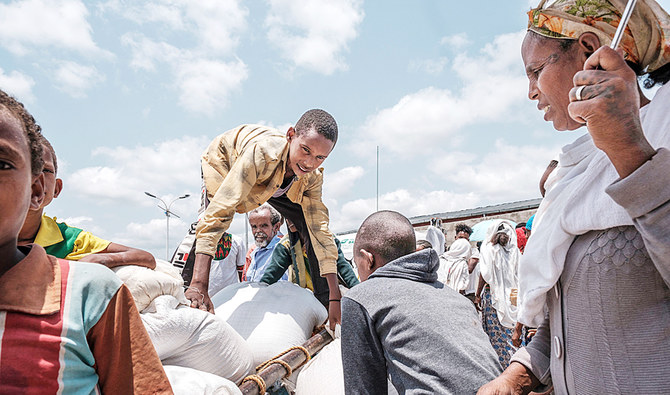 エチオピアのティグレ地方、フメラの南東50キロにあるベーカー村の近くで、若者が、アムハラ州政府が手配した食糧配給を手伝っている。（AFP）