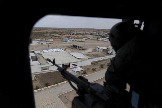 イラクのアンバール県におけるイラク軍第7旅団の軍事行動で、国境の町アルカイムの上空を飛ぶ軍用ヘリコプターに乗り込んで機関銃を受け持つイラク兵士を撮影した資料写真。（AP）