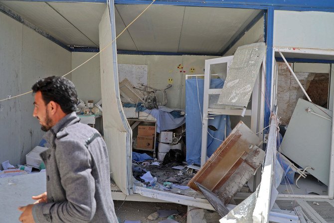 2021年3月21日、シリア北部アレッポ県のアタレブ村にて、政権軍が行ったとされる砲撃を受けて損壊した野戦病院入口の病室の前を通り過ぎる男性。（AFP）