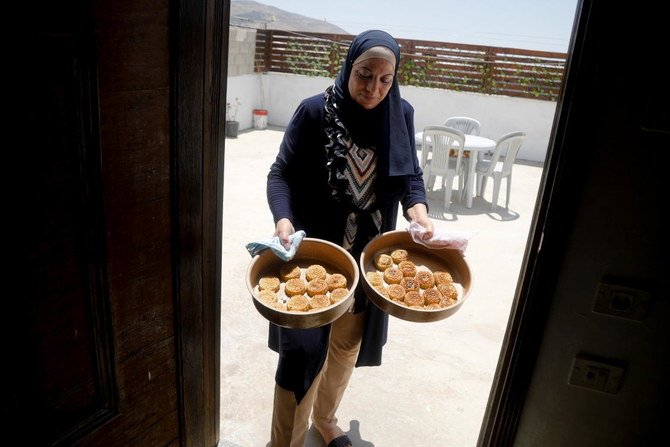 2021年7月18日、イスラエル占領下にある西岸のツバスで、イスラムの祝日イード・アル=アドハーに先立ち伝統的なケーキを用意するパレスチナ人のハナン・タウフィク氏。（ロイター）