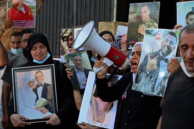 2021年7月9日にベイルートで実施された抗議集会の中で、レバノン人抗議者たちが、昨年のベイルート港の大規模爆発事故で亡くなった親族の遺影を掲げている。（AFP）