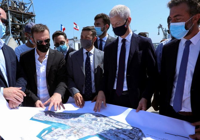 2021年7月13日、レバノンのベイルート港に建てられた穀物処理施設の落成式で、フランスのフランク・リーステール対外貿易・経済魅力担当大臣代理が他の人々と地図を見ている。（ロイター）