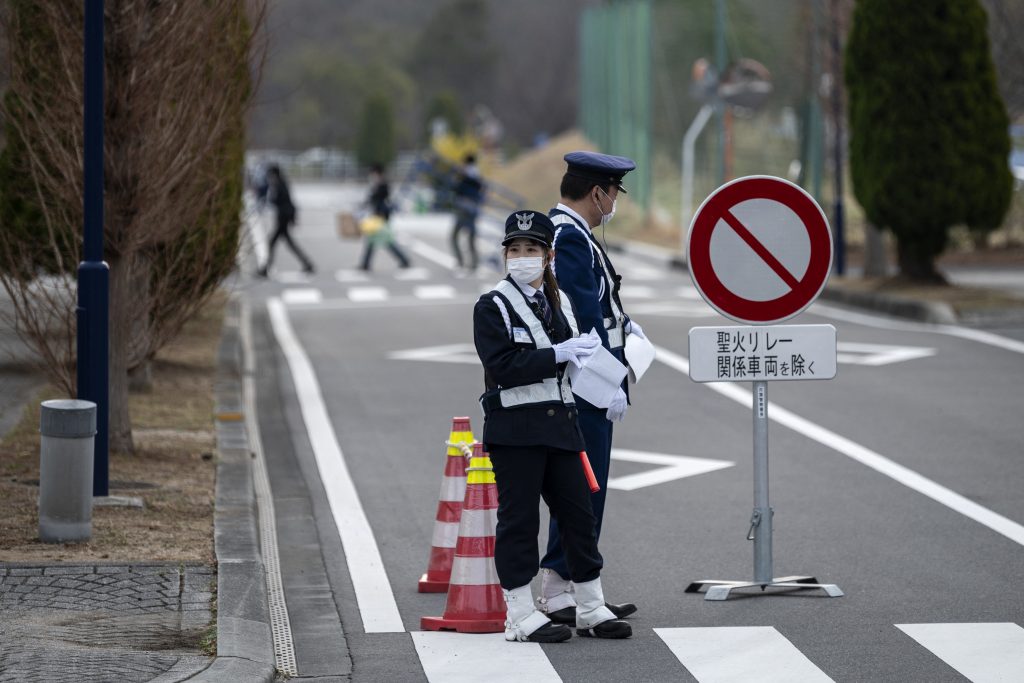 3月、東京2020オリンピック聖火リレーグランドスタートセレモニーの会場に警備員が立ち、当日、福島県楢葉町のJビレッジ国立訓練センターで行われた。 (AFP)