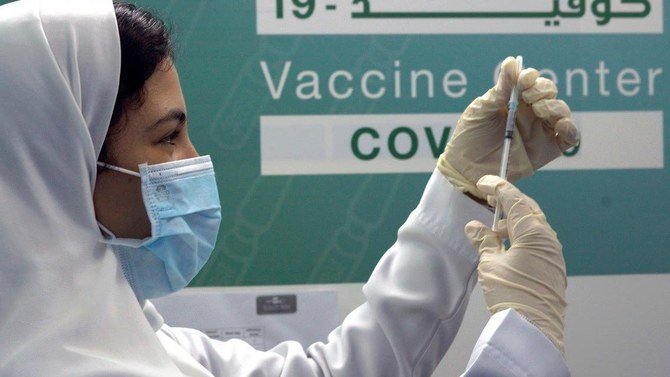 ワクチンセンターでファイザー社製ワクチンの注射準備をするサウジアラビア人医師。（AP）