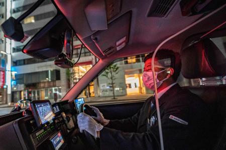 東京の銀座エリアを運転するタクシー運転手のカワグチ・ユウキ氏。2021年7月7日撮影。（AFP通信）