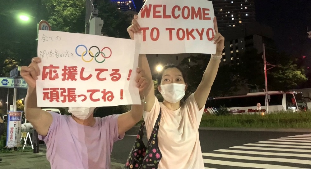 東京2020オリンピックの選手村の入り口で、選手たちを応援する日本の観戦者たち。（ANJ /ピエール・ブティエ）