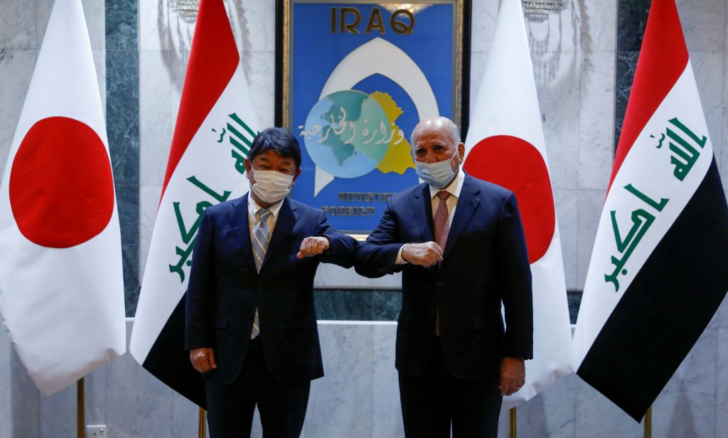 2021年8月21日、バグダッドでの会談前に、イラクのフアード・フセイン外相（右）と訪問中の茂木敏允外相が写真撮影のポーズをとる。（資料写真/AP）
