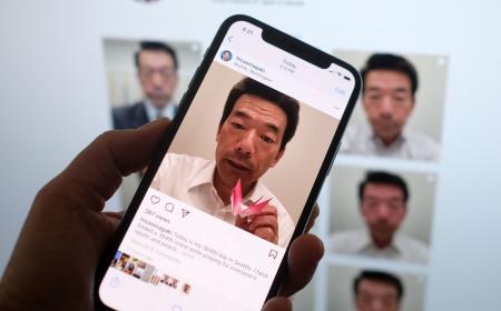スマートフォンから稲垣久雄氏のインスタグラムを見る人（2021年8月20日、ロサンゼルス）。（AFP通信）