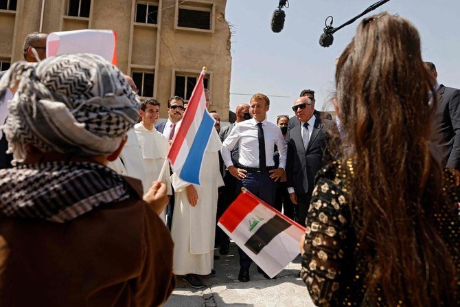 イラク第二の都市モスルの「時の聖母マリア教会」に到着し歓迎を受けるエマニュエル・マクロン仏大統領（中央）。(AFP)