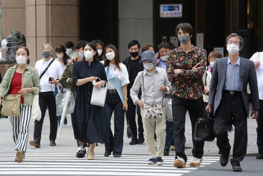 2021年8月16日、緊急事態宣言が発令されている東京の交差点を、新型コロナウイルスの感染拡大を防ぐためにマスクを着用して歩く人々。（資料写真/AP通信）