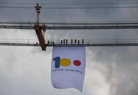 2021年8月26日、ルーマニアのブライラで、ドナウ川に架かる橋の作業現場で、ルーマニアと日本の外交関係樹立100周年を記念する横断幕を掲げる作業員ら。(AFP)