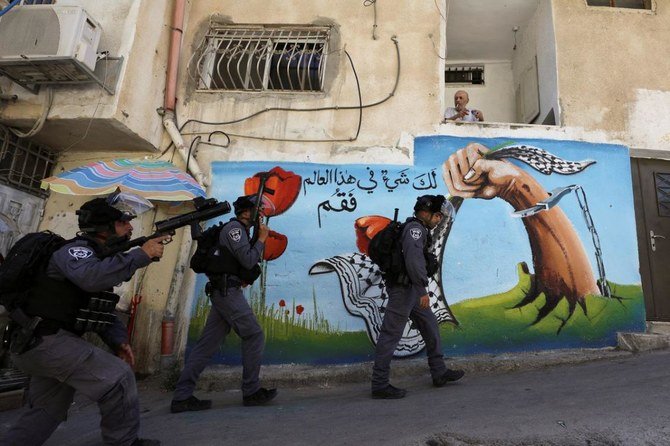 2021年6月29日、イスラエルが店舗を取り壊したことをめぐって発生したパレスチナとの衝突時、民家の前を歩くイスラエル治安部隊員。東エルサレムのパレスチナ人居住区シロワムにて。(ロイター)
