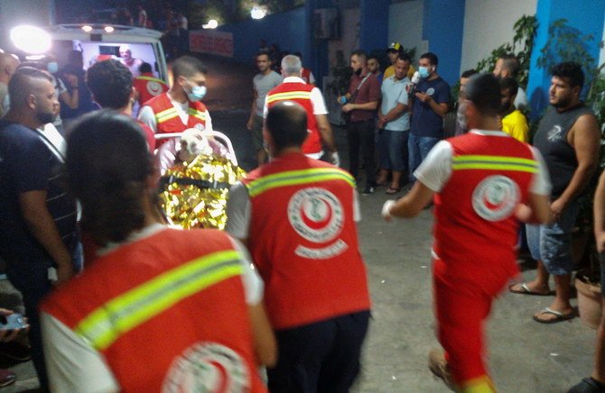 2021年8月15日、燃料トラック爆発事故で負傷した人をレバノン北部トリポリにある病院に搬送する救助隊員。（ロイター）