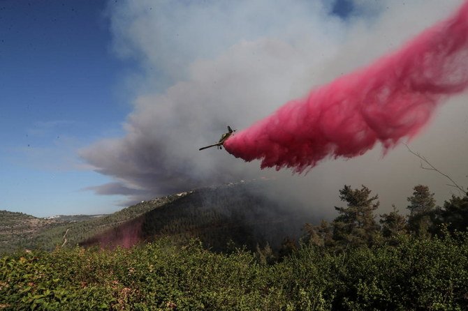 2021年8月15日、イスラエル・エルサレム郊外のショレッシュ村付近で発生した火災の消火を支援するために、消防機が難燃剤を散布している。（ロイター通信）