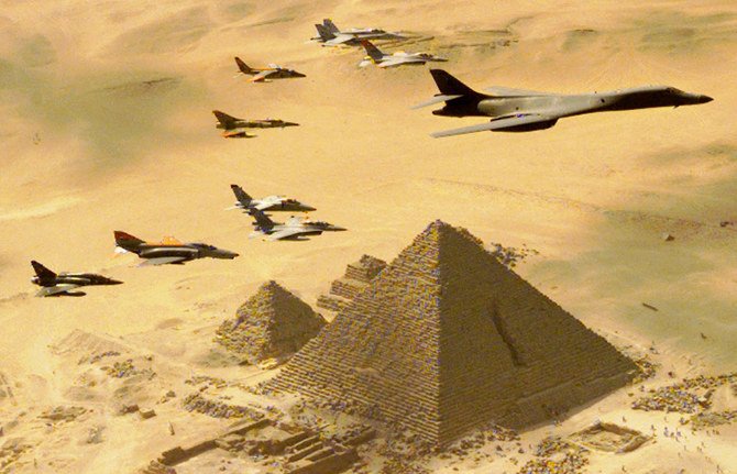 1999年10月25日、軍事演習「ブライトスター99」の一環で実施されたデモフライトにおいて、エジプトのギザの三大ピラミッドの上空を行く米空軍B-1B爆撃機と後に続く戦闘機。(AP)