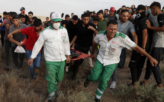 2021年8月21日土曜日、ガザ地区のイスラエルとの国境フェンスから医師たちが負傷者を運び出す。（AP）