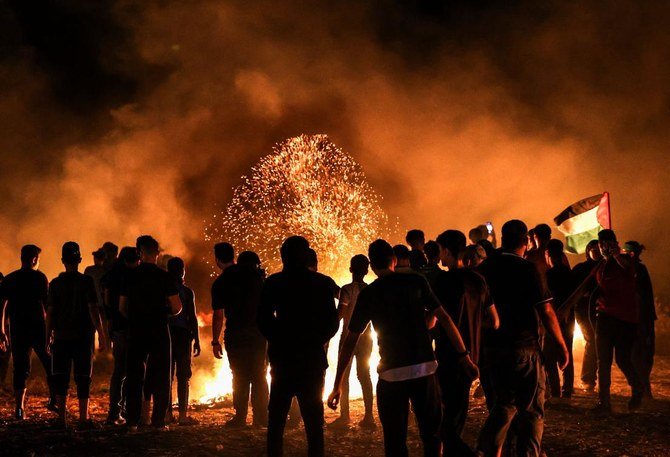 2021年8月28日、ガザ市東部にあるガザ地区とイスラエルの境界付近で抗議デモを行い、タイヤを燃やすパレスチナ人のデモ参加者。（AFP）
