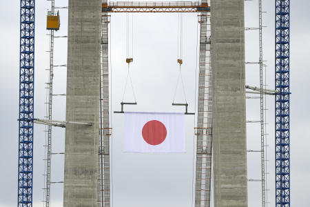 2021年8月26日（木）、ルーマニアのブライラにあるドナウ川に架かる吊り橋の建設現場で、日本とルーマニアの外交関係樹立100周年を記念する式典が行われ、構造物に日本の国旗が掲げられている。(AP)