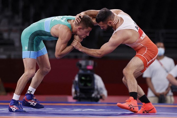東京2020オリンピック競技大会で開催されたレスリング男子フリースタイル57kg級の初期ラウンドで、アルジェリアのアブドルハク・へルバシェ選手(右)と戦うブルガリアのゲオルギ・ヴァンゲロフ選手(左)。(AFP)