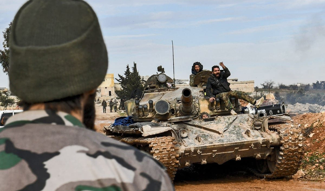 シリア国内で、シリア政府軍の兵士が戦車に上に座っている。（AFP／ファイル）