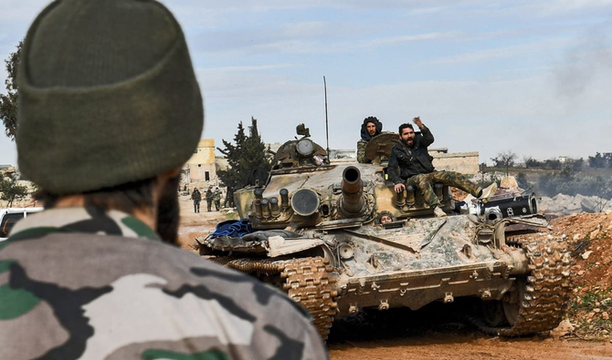 シリア国内で、シリア政府軍の兵士が戦車に上に座っている。(AFP/ファイル)