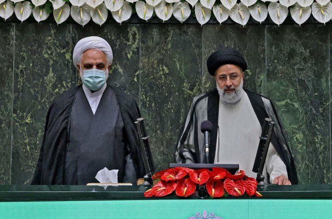 2021年8月5日、首都テヘランのイラン議会で宣誓するイランのイブラヒム・ライシ新大統領（右）（AFP）