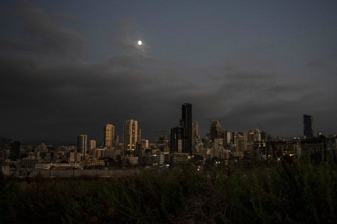 壊滅的経済危機など多重の危機に見舞われたレバノンにて、停電の間に暗闇が続くベイルートの上に昇る月。（AP）