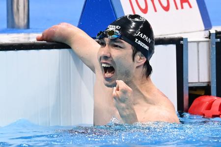 2021年8月26日に東京・アクアティックセンターで開催された東京2020パラリンピックの男子100m自由形S4水泳決勝で優勝した鈴木貴之氏は反応する。(AFP)