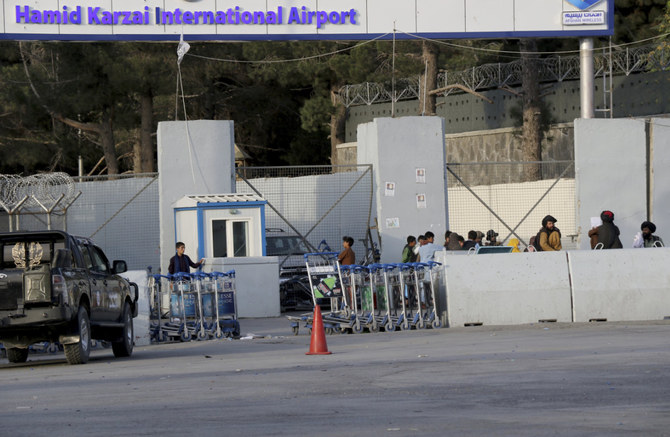 2021年8月28日、出国を希望するアフガニスタン人がカブール空港の正面ゲートを通過する際に、「特殊部隊」であるタリバンの「バドリ」部隊の戦闘員が見張りをしている。(AFP)